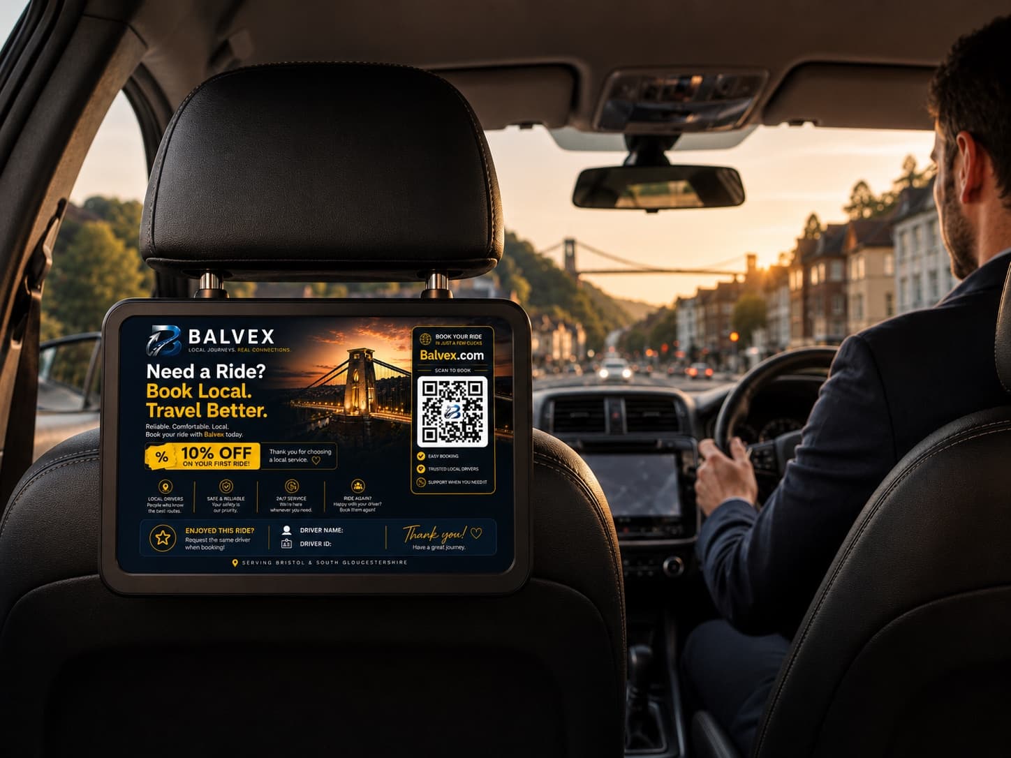 A passenger's view of an in-vehicle advert screen mounted on the headrest of a Bristol private-hire car at sunset